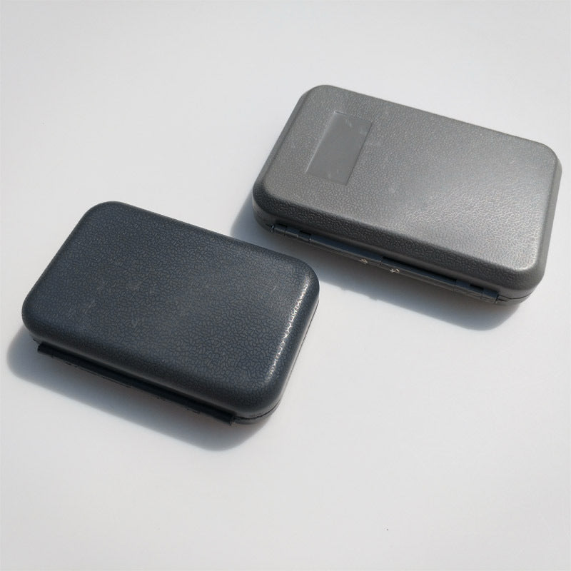 Closed dark and gray fly boxes viewed from above