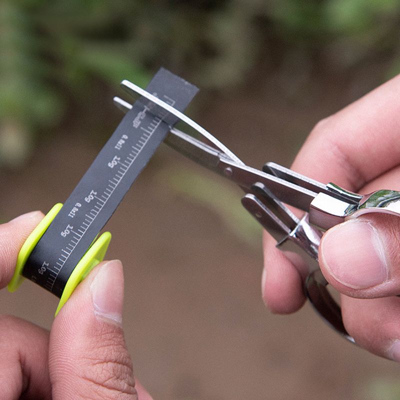 Silver folding scissors cutting material in a close-up demonstration